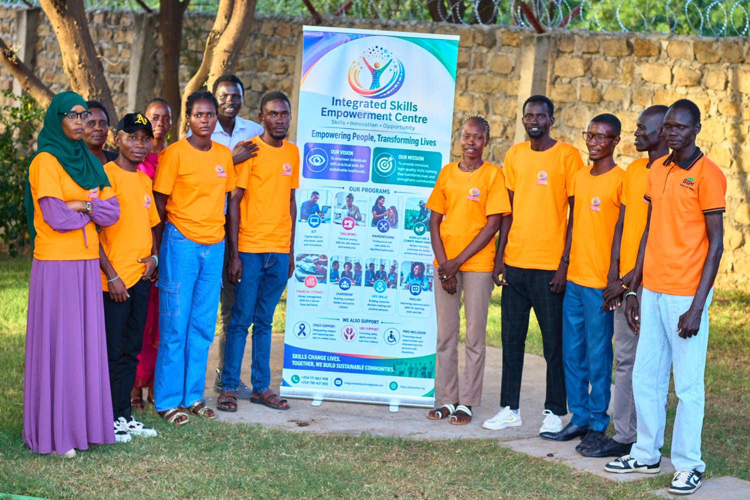 The ISEC team standing together beside the programme banner
